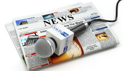 generic newspaper with news microphone sitting on top of it